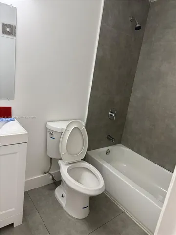 a white toilet sitting next to a bath tub
