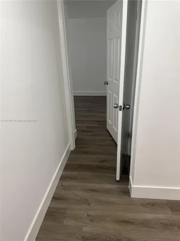 a view of a hallway with wooden floor and entryway