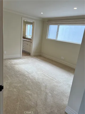 an empty room with closet and a hallway