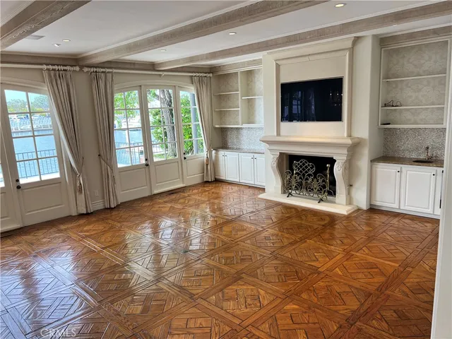a view of empty room with wooden floor and fireplace