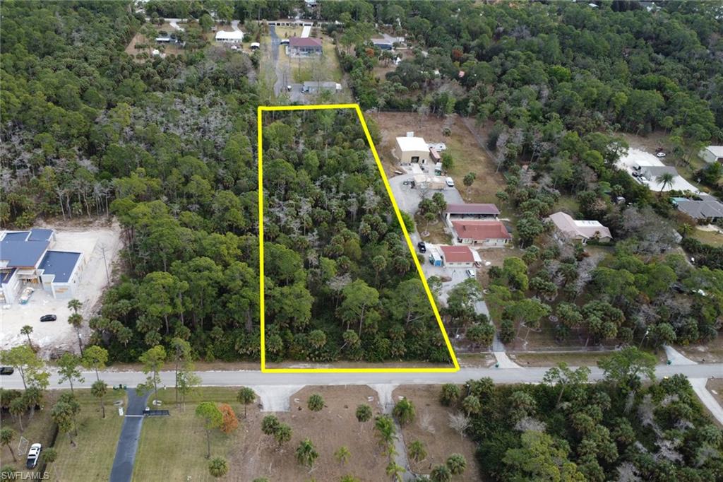 Aerial view of property's location with property parcel outlined and a forest