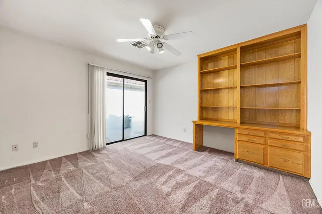 a view of an empty room with a cabinet and a window