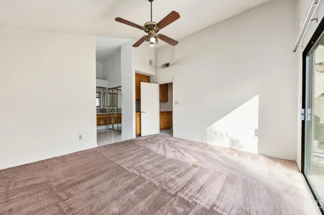 a view of a big room with closet and a ceiling fan