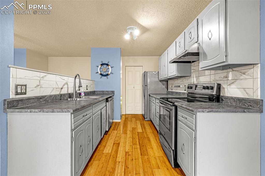 130 Scotland Road, Unit D Pueblo, CO 81001 - Photo 6 of 20 a kitchen with stainless steel appliances granite countertop a sink stove and refrigerator