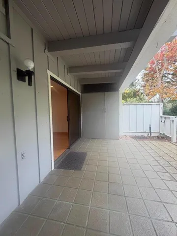 a view of an empty room with a fireplace and a window