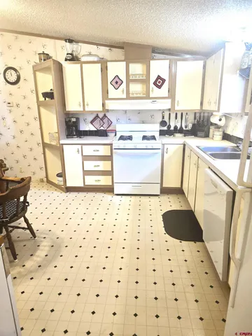 a kitchen with a sink a stove cabinets and a window