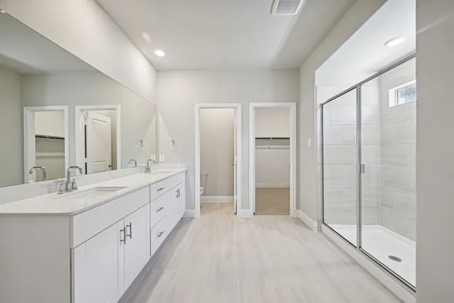 a spacious bathroom with a double vanity sink and a mirror