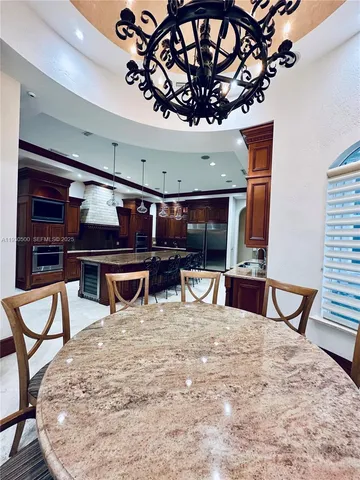 a living room with furniture a chandelier and a piano