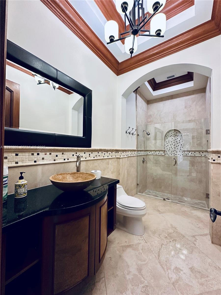 6180 Southwest 132nd Street Pinecrest, FL 33156 - Photo 20 of 75 a bathroom with a sink a toilet and a mirror