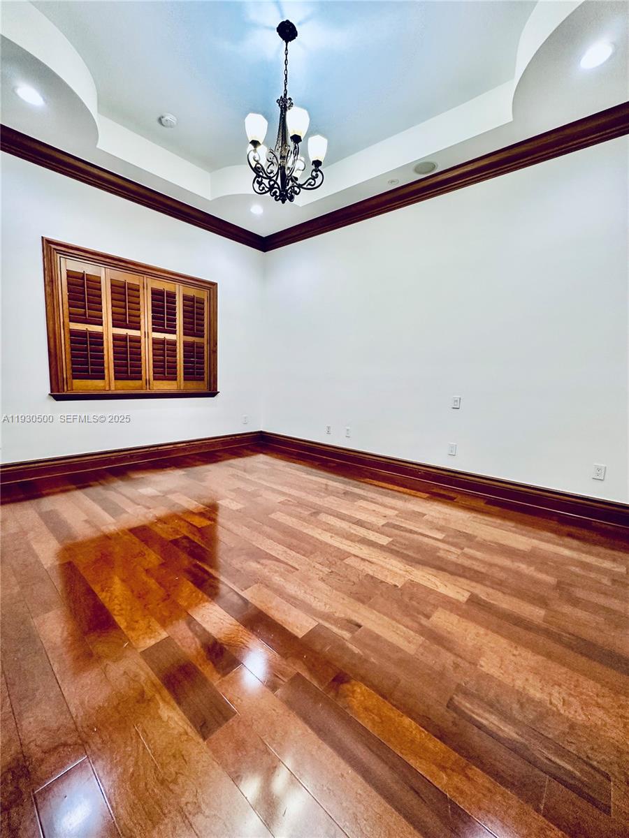 6180 Southwest 132nd Street Pinecrest, FL 33156 - Photo 34 of 75 a view of an empty room with wooden floor and chandelier