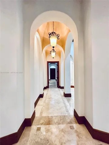 a view of a big room with windows and chandelier