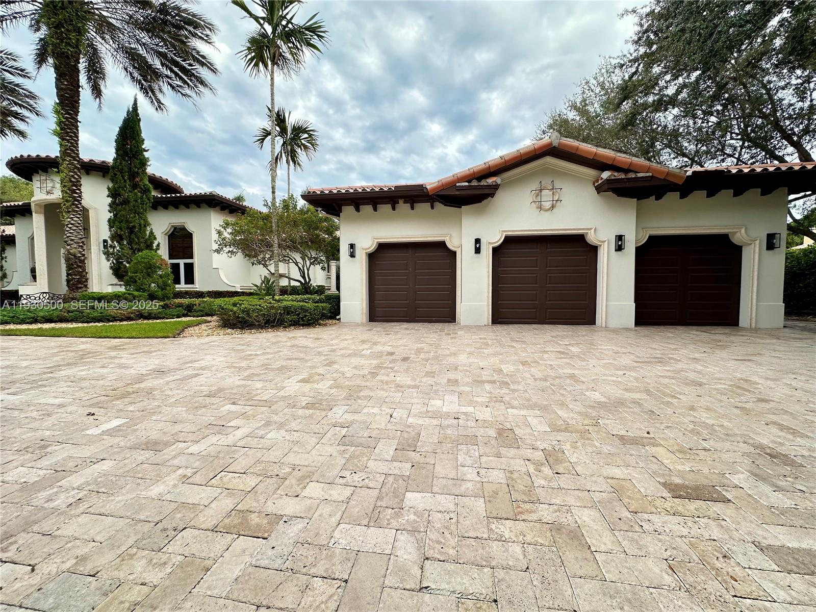 6180 Southwest 132nd Street Pinecrest, FL 33156 - Photo 69 of 75 a front view of a house with a yard and garage