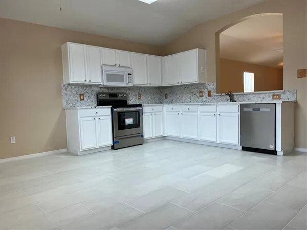 a kitchen with white cabinets and white appliances