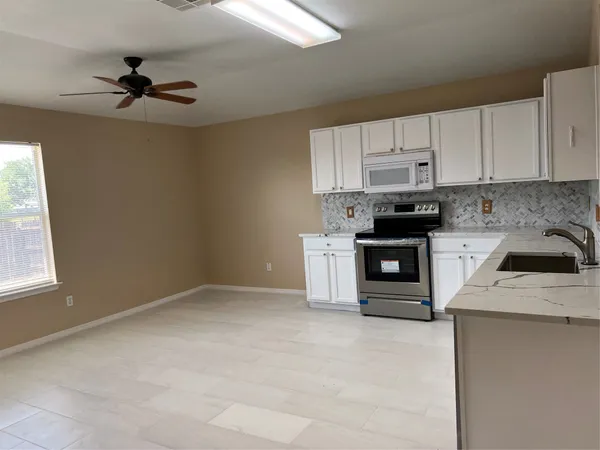 a kitchen with stainless steel appliances kitchen island granite countertop a sink cabinets and a stove