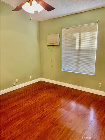 an empty room with wooden floor and a window