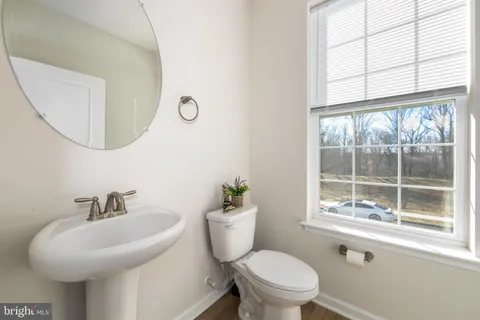a bathroom with a sink a toilet and a window