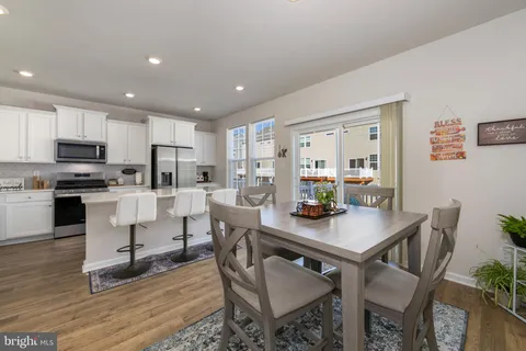 a kitchen with a dining table chairs and refrigerator