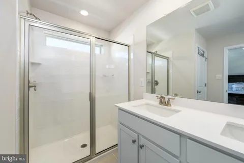 a bathroom with a shower sink and mirror