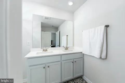 a bathroom with a double vanity sink and mirror