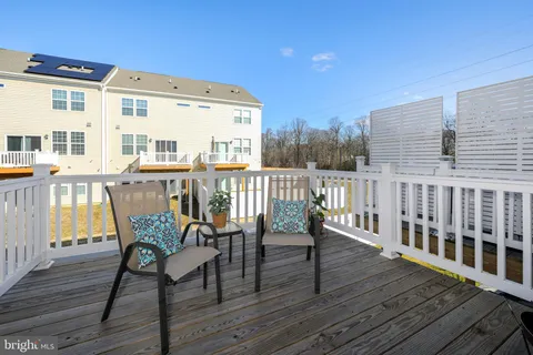 a view of a roof deck with table and chairs and wooden floor