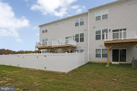 a front view of house with yard and ocean