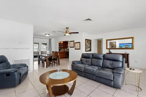 a living room with furniture and a dining table with wooden floor