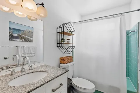 a bathroom with a granite countertop sink mirror vanity and toilet