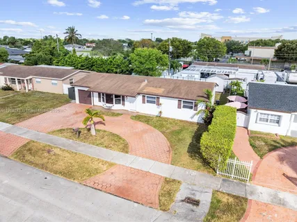 an aerial view of a house with a garden and lake view