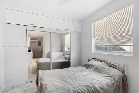a bedroom with a bed and a large mirror