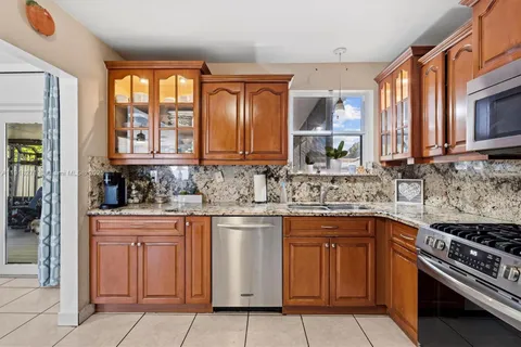 a kitchen with stainless steel appliances granite countertop a stove sink and cabinets