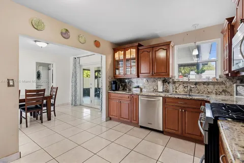 a large kitchen with kitchen island granite countertop a sink and cabinets