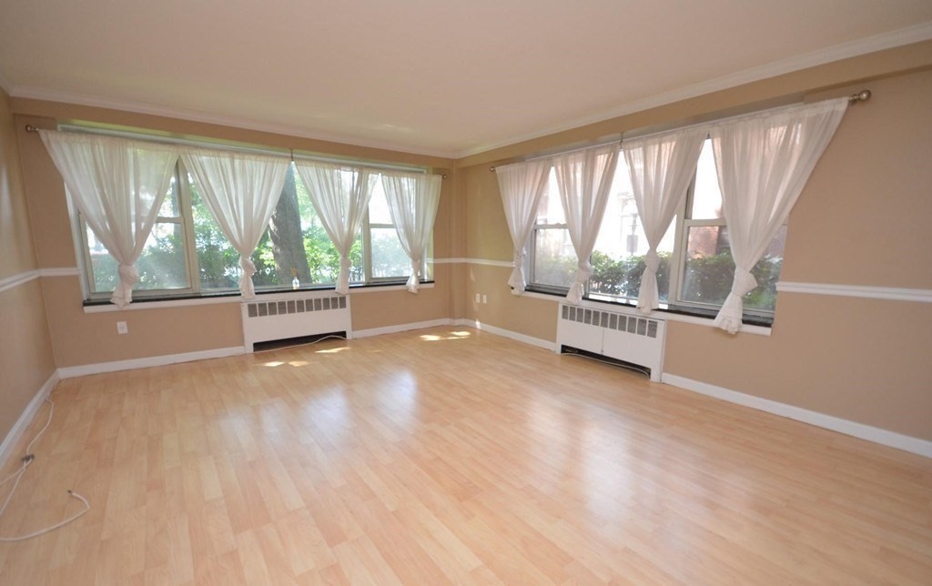 145 Pinckney Street, Unit 135 Boston, MA 02114 - Photo 1 of 7 an empty room with wooden floor and windows
