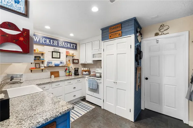 a view of a hallway to a livingroom with furniture and windows