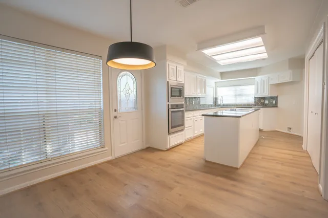 a view of a kitchen with a sink cabinets and wooden floor