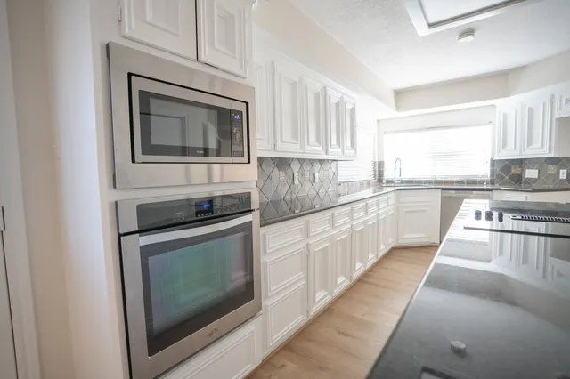 a kitchen with stainless steel appliances granite countertop a stove microwave and cabinets