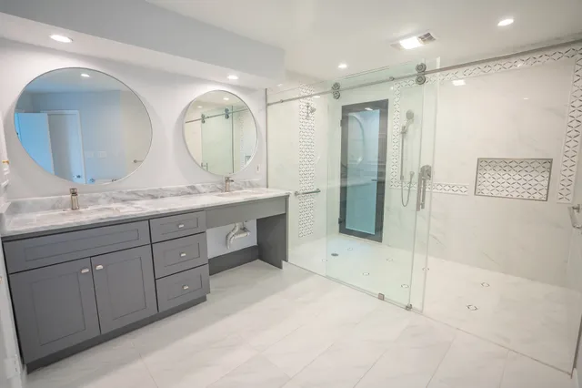 a spacious bathroom with a granite countertop sink mirror and shower