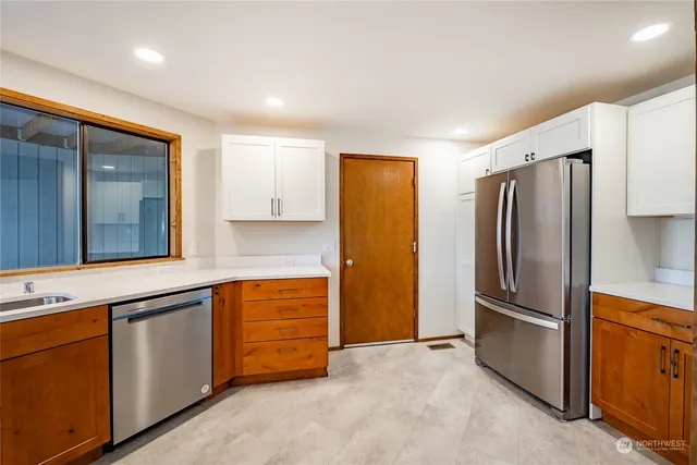 a kitchen with stainless steel appliances granite countertop a refrigerator and a stove
