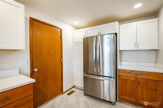 a metallic refrigerator freezer sitting in a kitchen