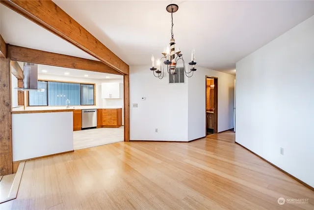 a view of a livingroom with wooden floor and a chandelier