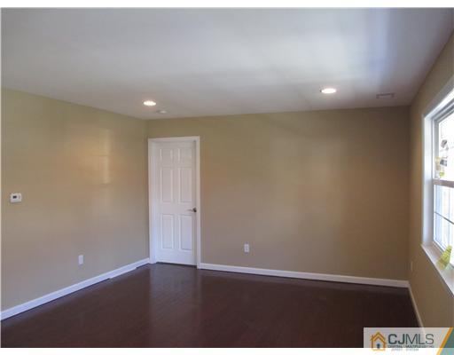 18 Colton Road Edison, NJ 08817 - Photo 2 of 10 an empty room with wooden floor and windows