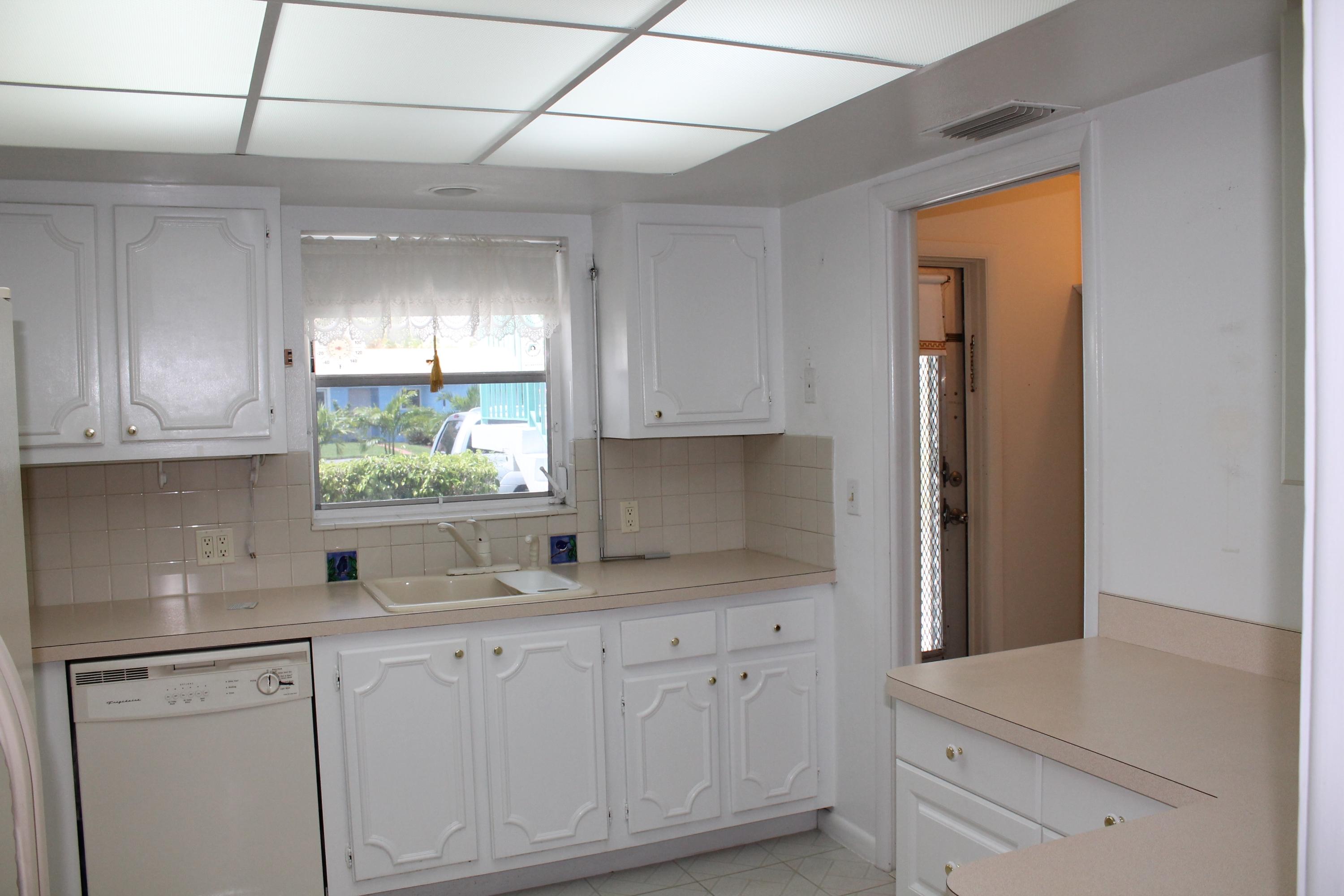 1248 Surf Road, Unit 2 Singer Island, FL 33404 - Photo 4 of 13 a kitchen with white cabinets and window