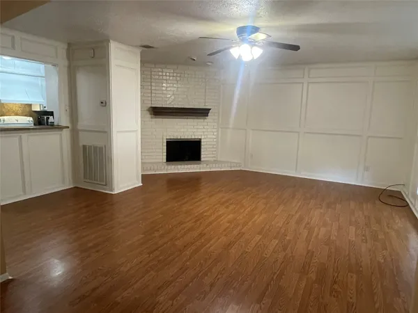 a view of empty room with wooden floor and fireplace