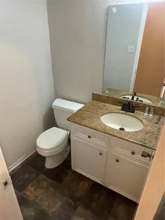 a bathroom with a granite countertop bathtub sink mirror and toilet