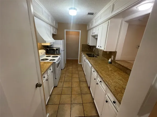 a large kitchen with a stove a refrigerator a sink and dishwasher