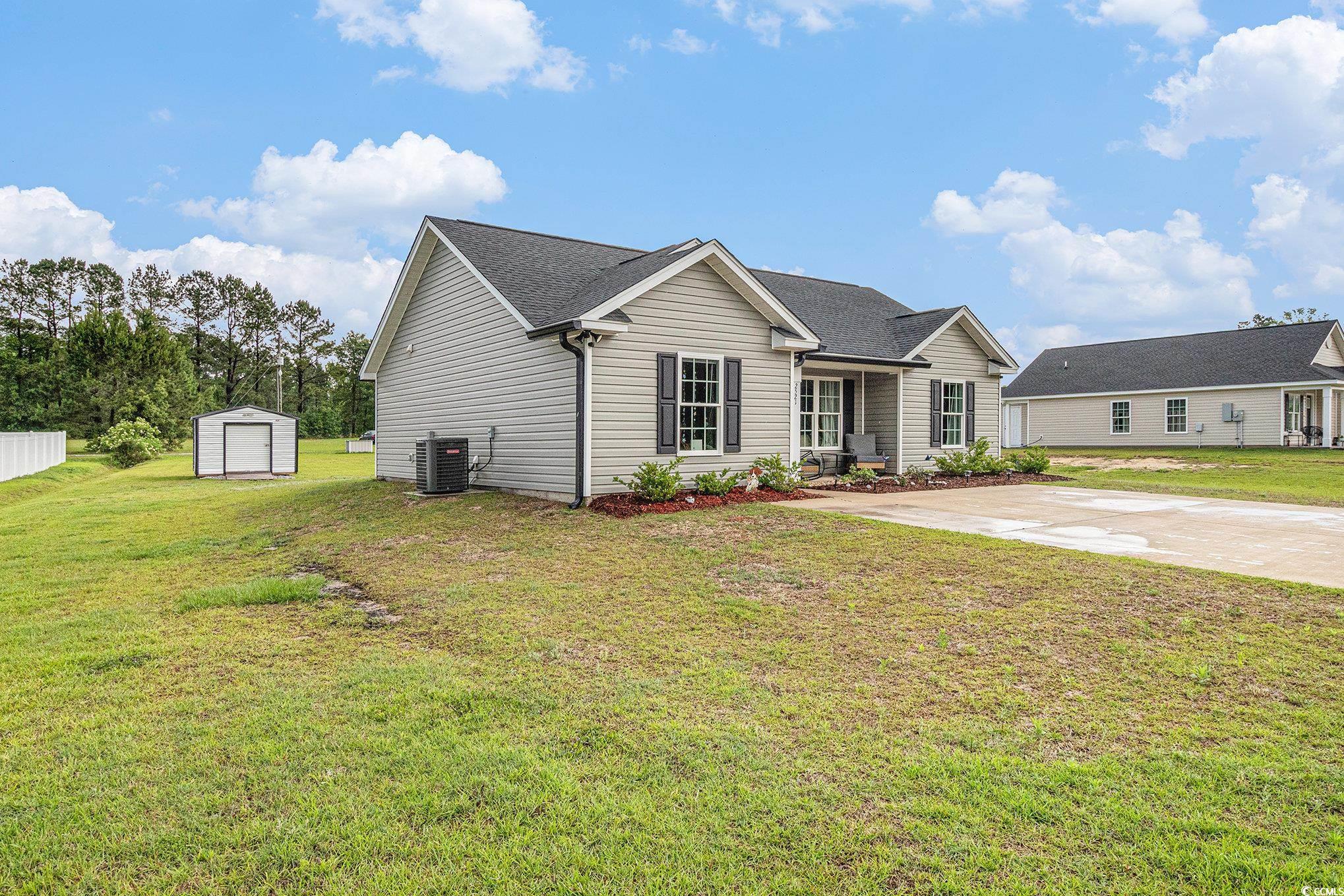 2521 Wise Road Conway, SC 29526 - Photo 2 of 20 View of front facade featuring central AC, a storage unit, an outbuilding, and a front yard