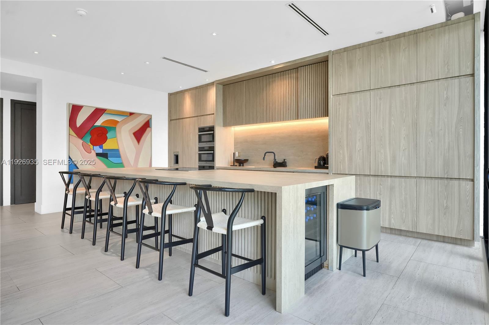 5501 Pine Tree Drive Miami Beach, FL 33140 - Photo 25 of 60 a dinning room with stainless steel appliances kitchen island granite countertop furniture and a refrigerator