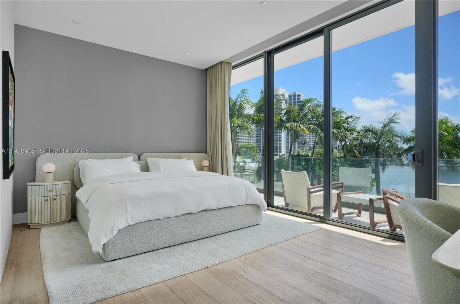 5501 Pine Tree Drive Miami Beach, FL 33140 - Photo 41 of 60 a bedroom with a large bed and a large window with outer view
