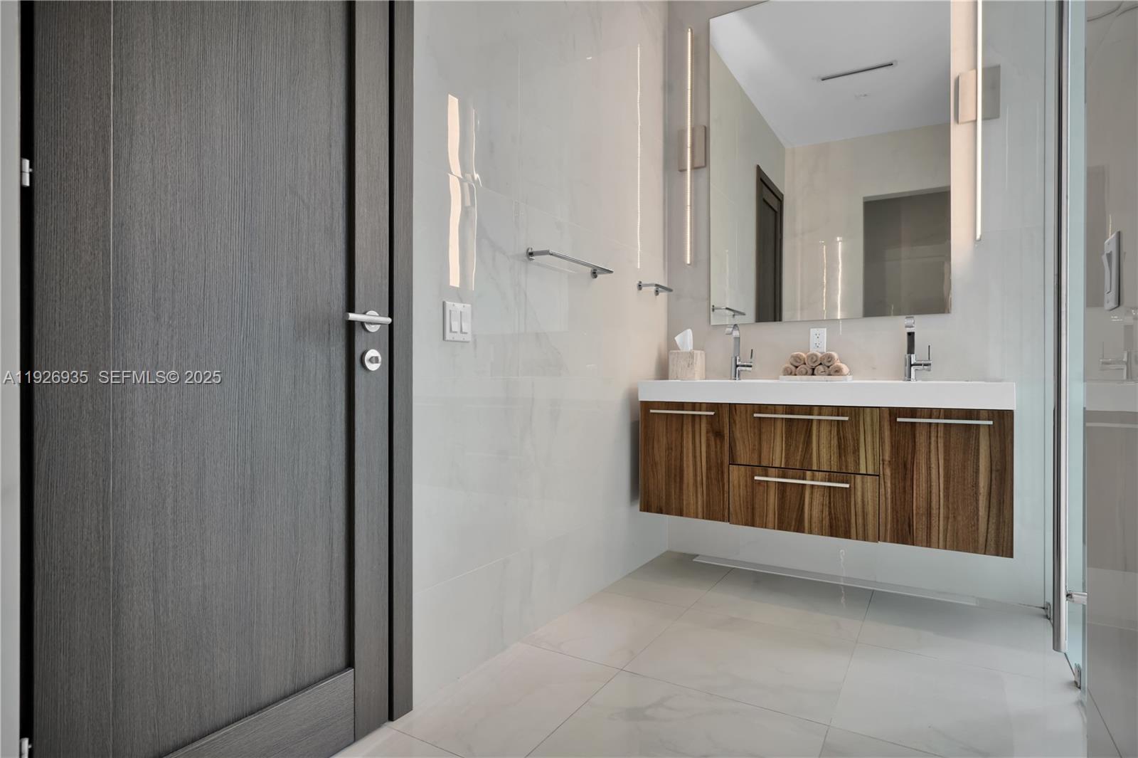 5501 Pine Tree Drive Miami Beach, FL 33140 - Photo 49 of 60 a bathroom with a double vanity sink and mirror