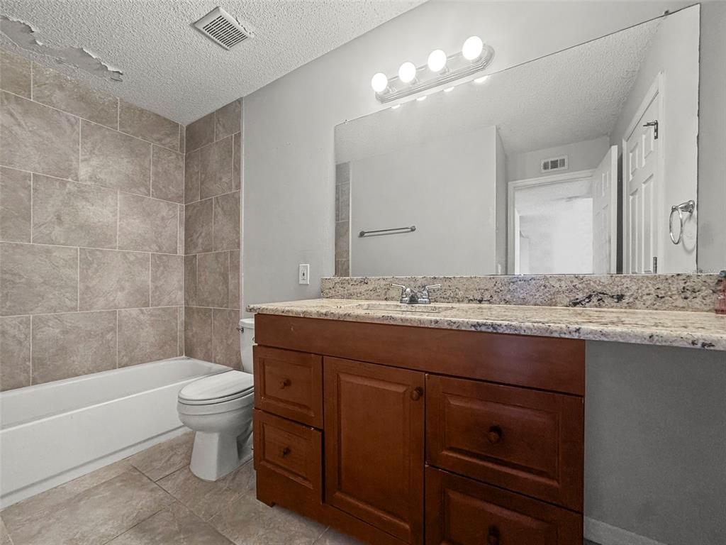 455 Alt 19, Unit 175 Palm Harbor, FL 34683 - Photo 19 of 35 a bathroom with a granite countertop sink a toilet and bathtub