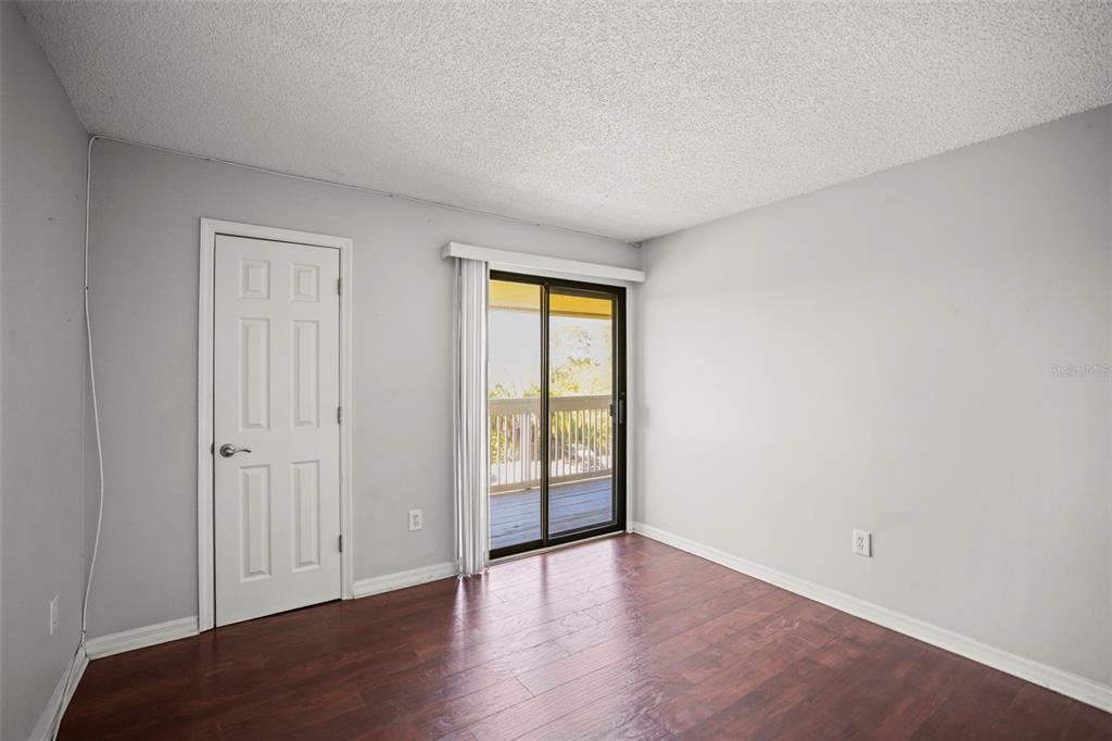 455 Alt 19, Unit 175 Palm Harbor, FL 34683 - Photo 23 of 35 an empty room with wooden floor and sliding door